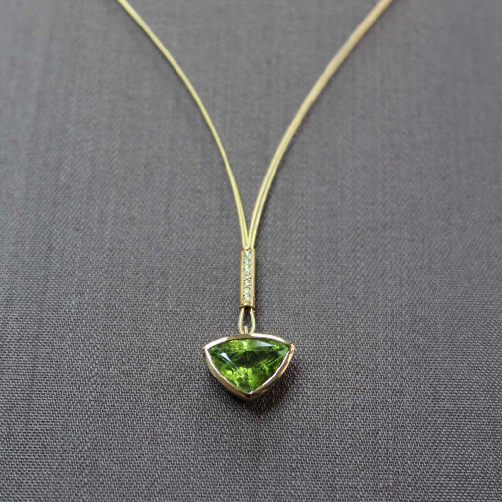 Ein großer Peridot im Trillantschliff, kombiniert mit Brillanten, gefasst in 18ct Gold